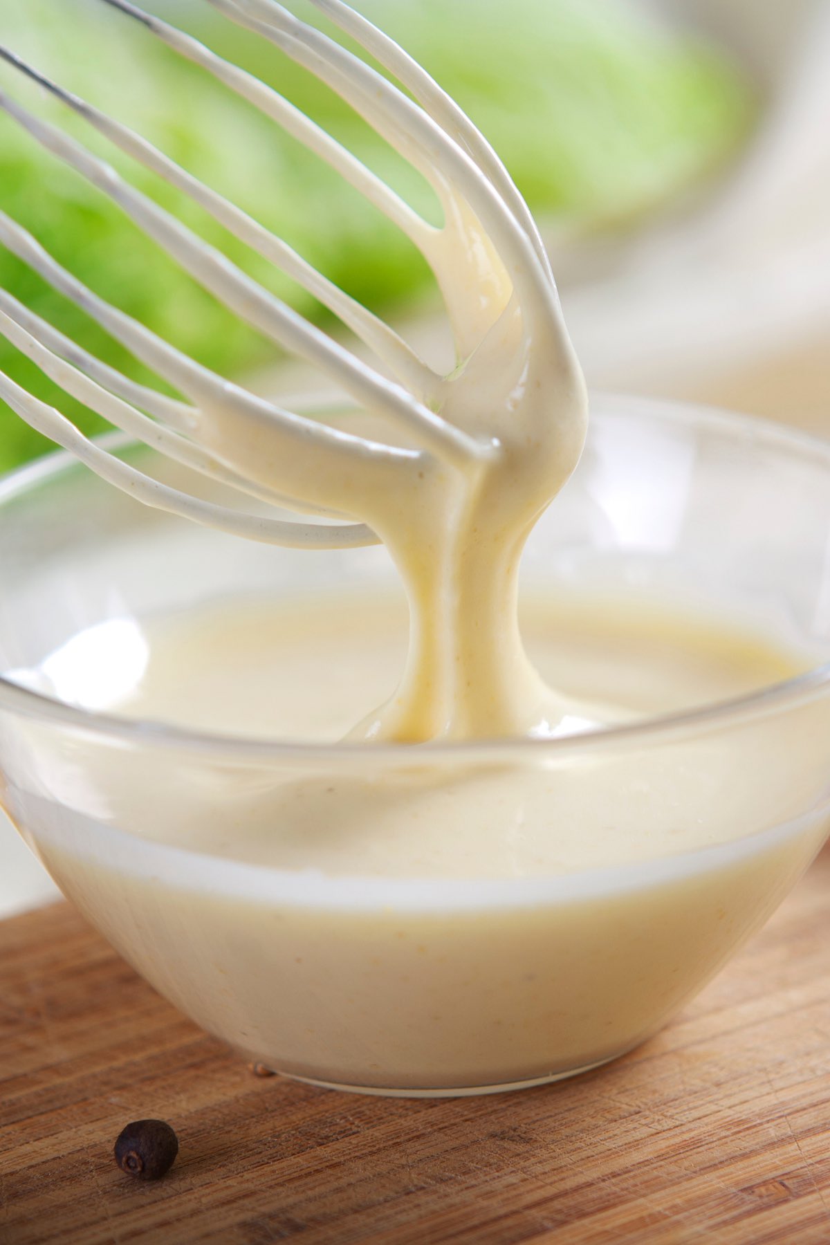 Photo showing homemade mayo in a clear mixing bowl.