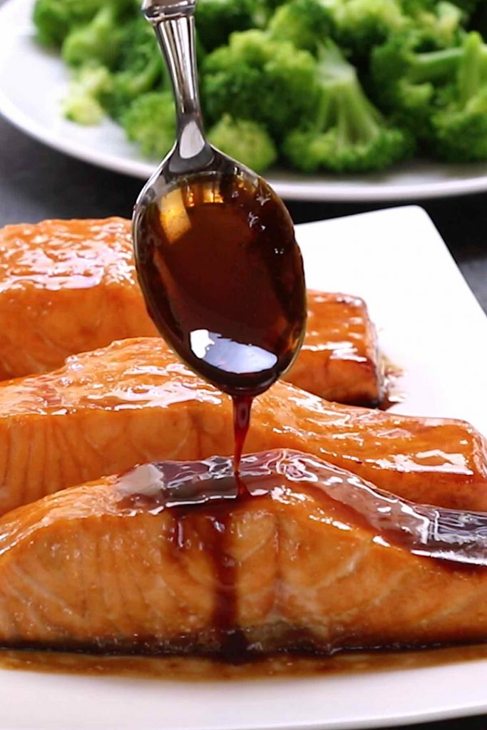 Closeup of drizzling unagi sauce onto grilled salmon.