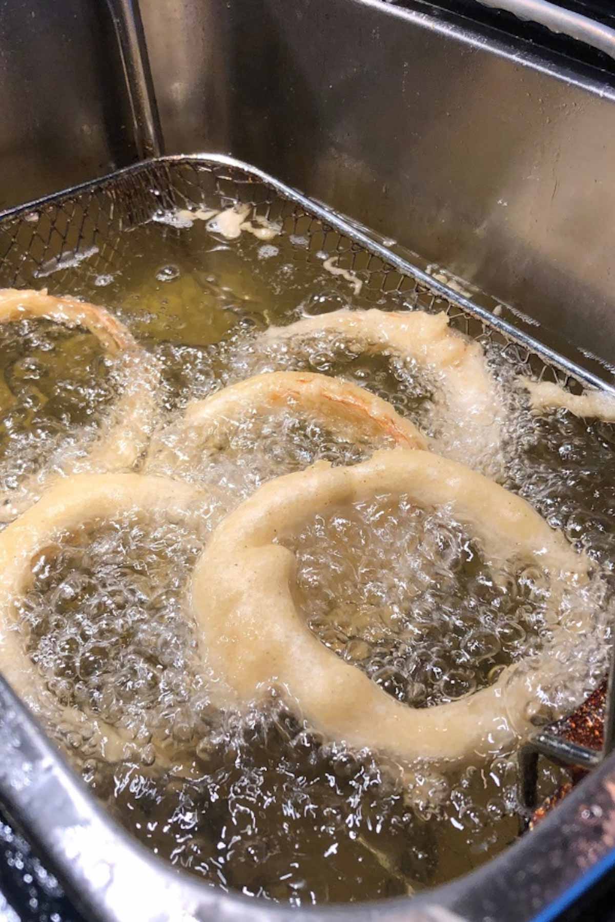 Photo showing deep frying the onion rings.