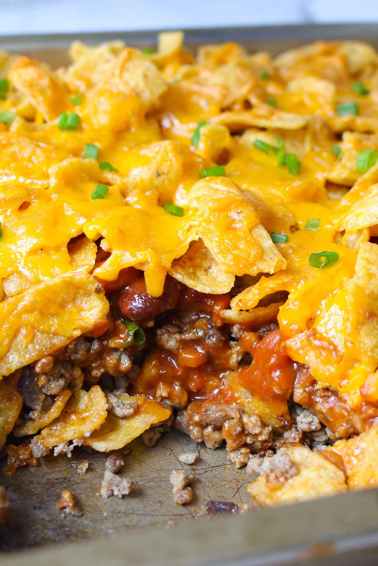 Take everything you love about a taco salad and turn it into a warm, cheesy, baked Walking Taco Casserole! The entire family will love this Tex-Mex recipe, with its succulent ground beef, gooey cheddar cheese and crunchy Fritos, Doritos, or Tortilla Chips. It’s easy to assemble ahead of time and bake later for a quick dinner!