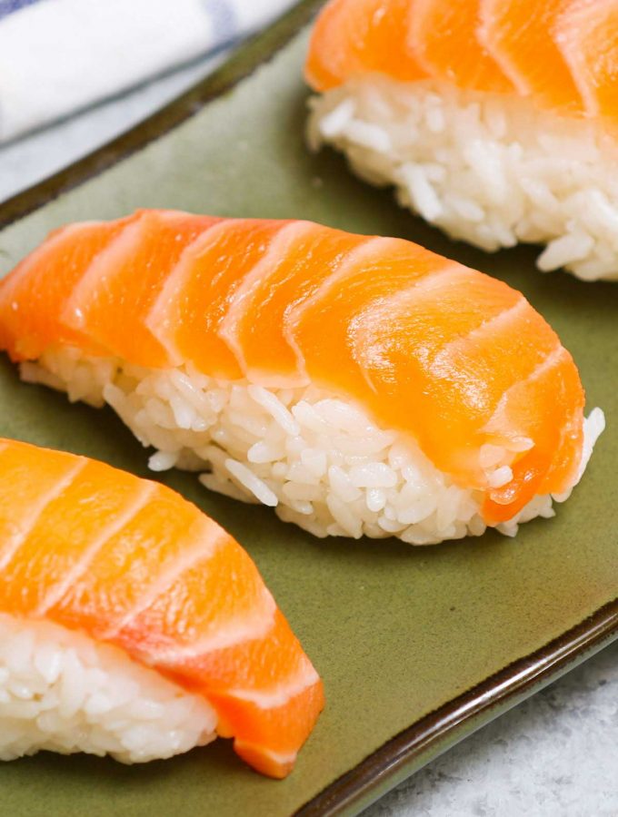 An easy and complete homemade Nigiri tutorial with lots of tips and tricks. Unlike maki sushi, nigiri isn’t rolled. Instead, it’s comprised of a thin slice of raw or cooked seafood like salmon or shrimp atop a mound of vinegary rice. You’ll learn everything about Japanese nigiri including the difference between nigiri and sashimi, and how to make perfect nigiri at home.