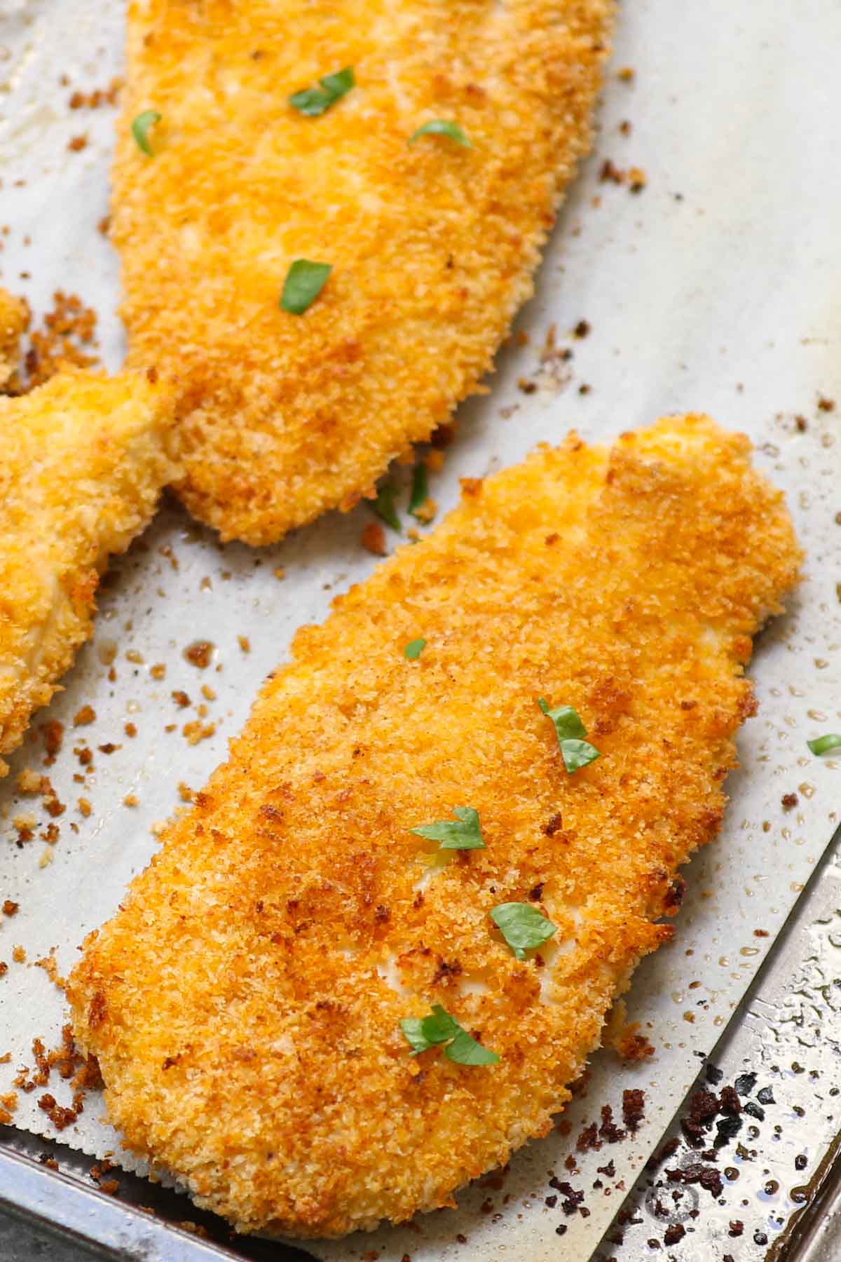 Crispy and crunchy Oven Baked Chicken Fillets are life-changing! Chicken breast fillets are soaked in lemon garlic flavors and then coated with a golden parmesan panko crumb.  No mess, no flour needed, no deep-frying! This restaurant-quality recipe is so easy to make and popular with kids and adults!