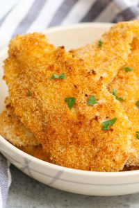 Crispy and crunchy Oven Baked Chicken Fillets are life-changing! Chicken breast fillets are soaked in lemon garlic flavors and then coated with a golden parmesan panko crumb. No mess, no flour needed, no deep-frying! This restaurant-quality recipe is so easy to make and popular with kids and adults!