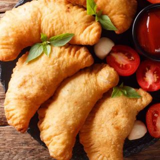 Easy Panzerotti (or Panzarotti) is an Italian savory turnover like a mini pizza pocket and it’s super easy to make at home! A pizza dough crust is filled with all the classic toppings – pepperoni, cheese, and your choice of sauce. These semi-circular pockets are then baked or deep-fried to golden perfection. If this sounds like something you might like (how can it not?), check out this authentic recipe.