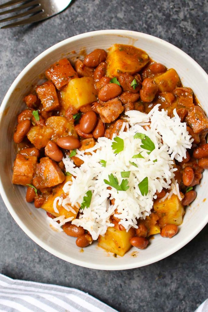 Puerto Rican Rice and Beans are saucy, flavorful, and comforting. Delicious Goya red beans are simmered in sofrito, tomato and sazon sauce! This Puerto Rican staple is also known as Habichuelas or stewed beans, and leftovers are perfect for meal prep.