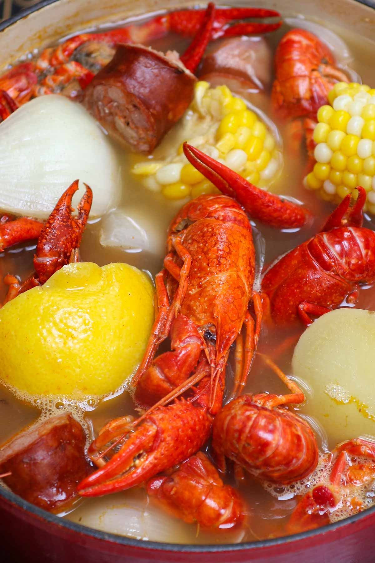 This Louisiana Crawfish Boil contains crawfish, corn, potatoes, and smoked sausage, all boiled in Old Bay seasoning flavored Cajun-style broth. Serve it with the classic seafood garlic butter sauce for the ultimate crawfish boil recipe.