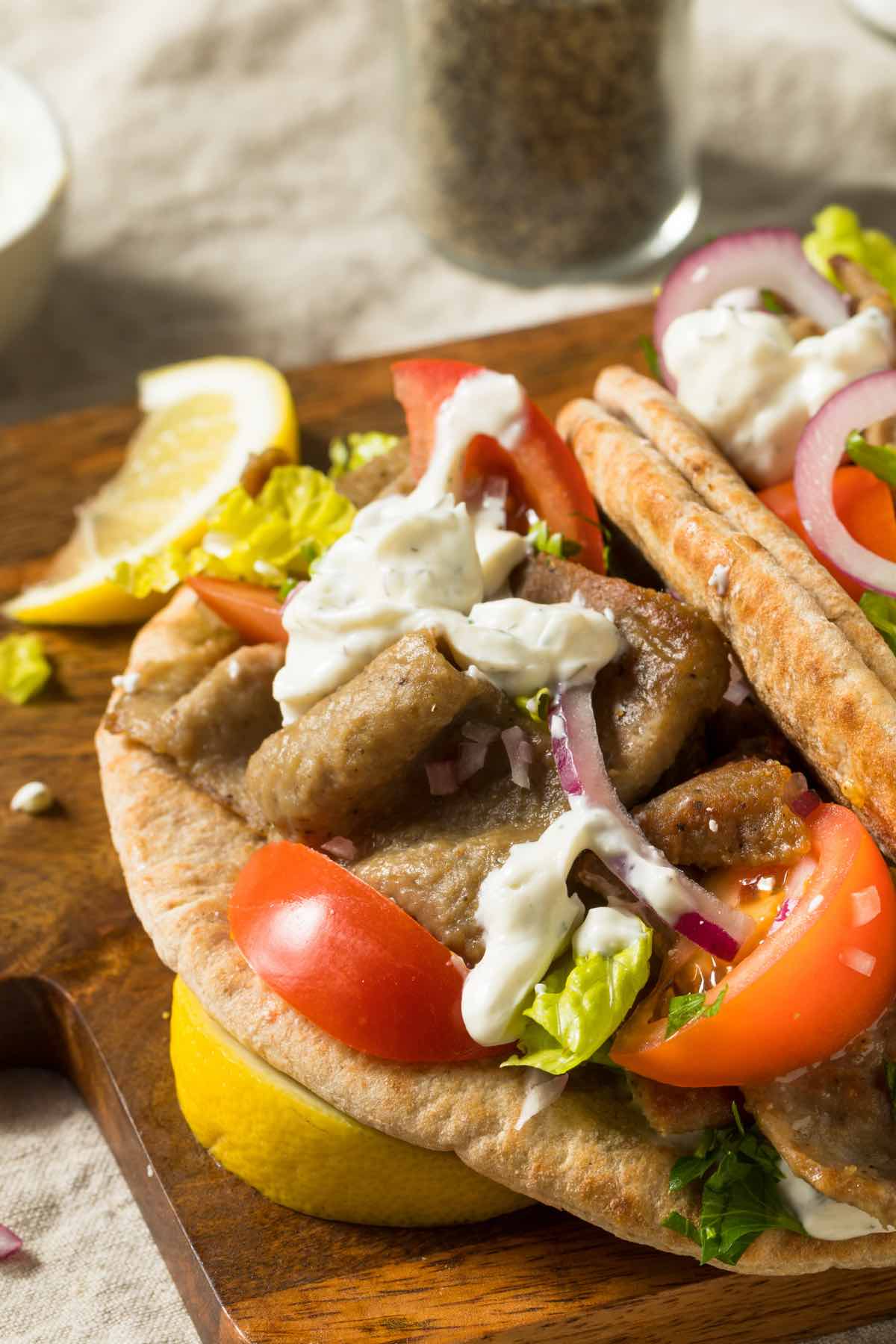 The Easy Greek Gyro Sandwich is gyro meat, fresh vegetables, and feta cheese wrapped in warm pita bread. You can top it with Tzatziki sauce, and it's the ultimate sandwich for Greek food lovers!
