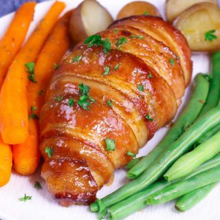 Bacon wrapped chicken is tender, juicy, and full of flavor. Chicken is rubbed with brown sugar and seasoning, then wrapped in bacon and baked to perfection. It’s one of our favorite fancy dinner ideas for a special occasion.