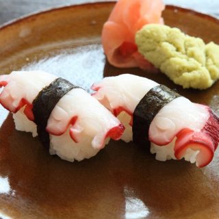Japanese Octopus Sushi, or Tako nigiri is a traditional Japanese sushi roll that consists of a small ball of seasoned sushi rice topped with slices of sashimi-grade octopus. The rice and octopus are held together by a thin strip of nori.