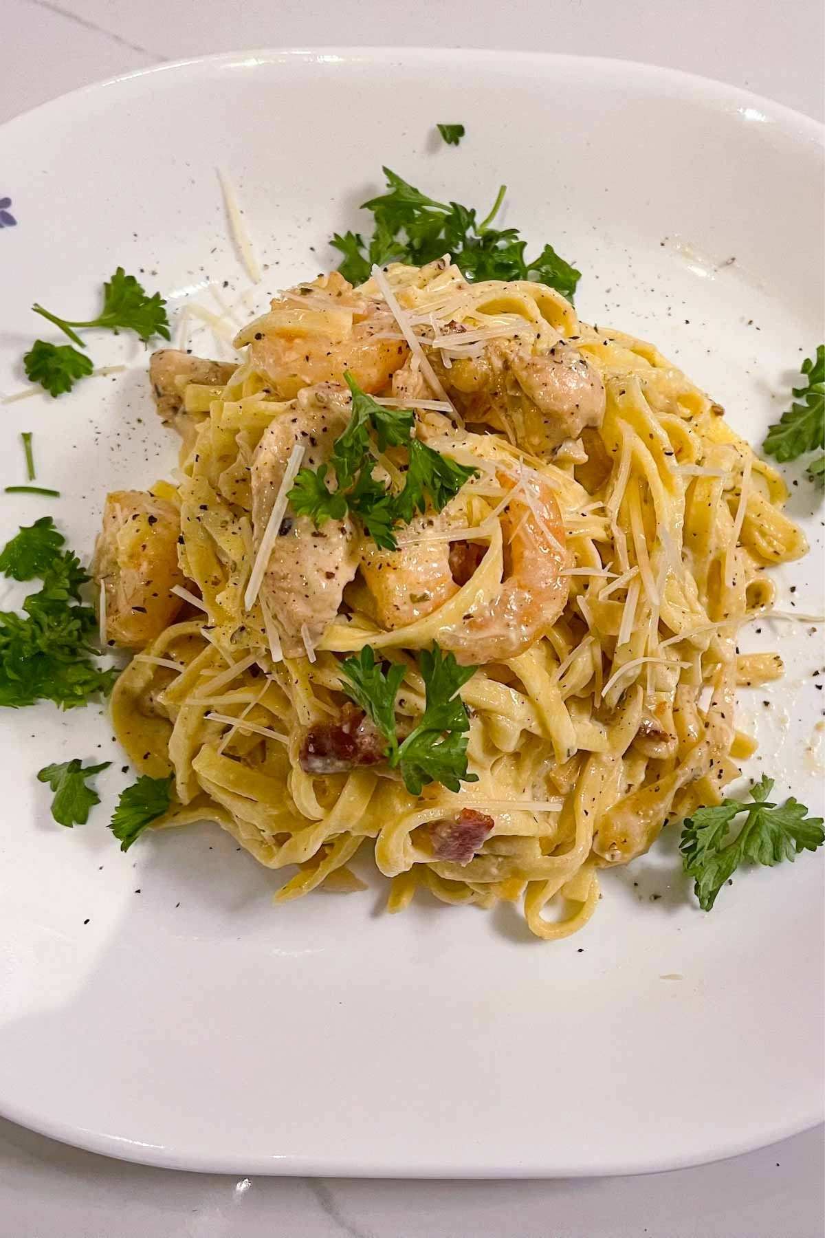 Tired of boring mid-week lunches? Kick it up a notch with this tasty Chicken and Shrimp Carbonara, just like they do at Olive Garden! Made with fresh, flavorful ingredients and seasoned with herbs, this is a meal the whole family will enjoy.