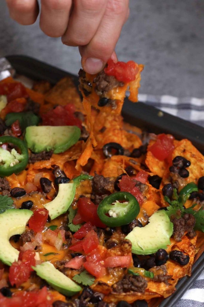 Want to know a neat trick for making the best nachos at home? Use Doritos! Instead of plain tortilla chips, these Dorito Nachos are made with flavorful Doritos chips. Add all your favorite toppings and pop it in the oven for the ultimate snack!