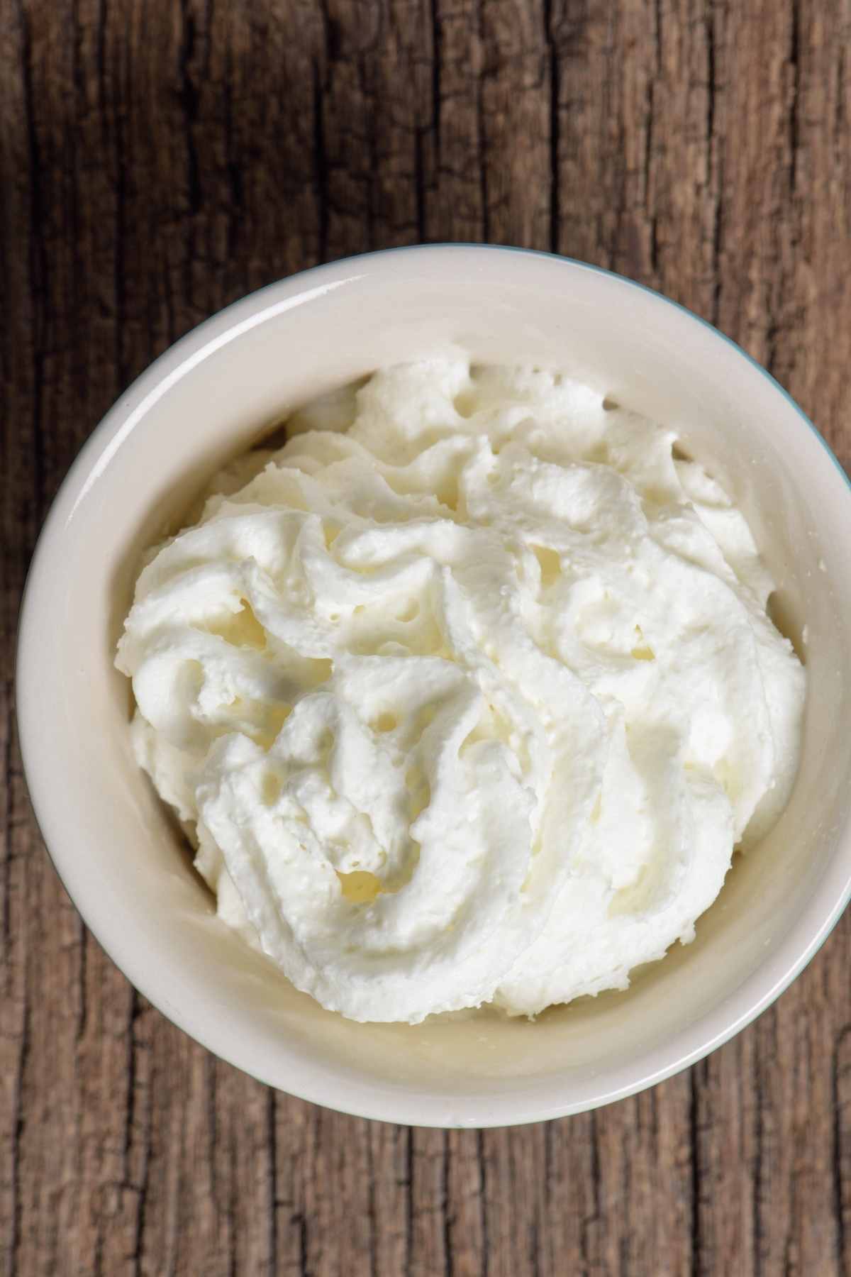 Do you want to make a light and fluffy Cool Whip Frosting from scratch? This super easy recipe has a yummy vanilla flavor and is the perfect way to finish a cake or cupcakes.