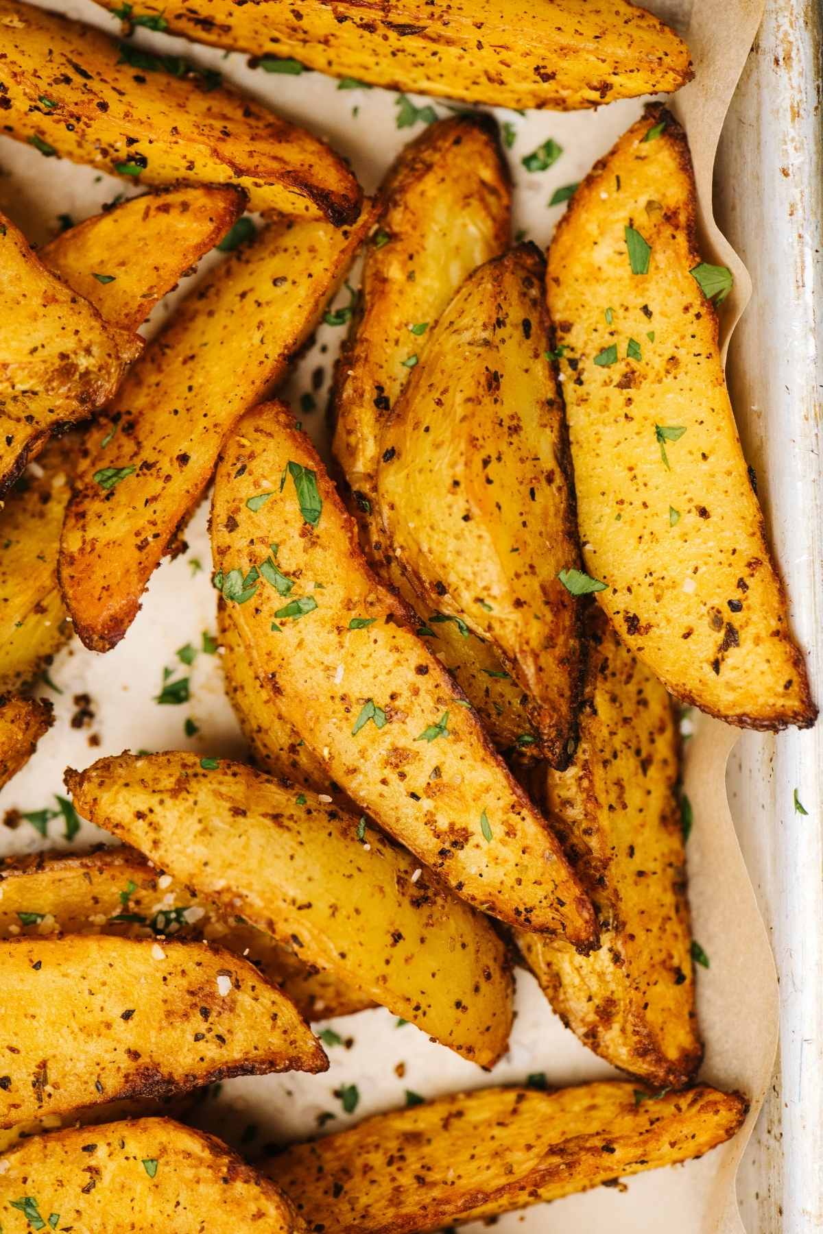The perfect potato wedges are soft and tender on the inside and crisped to perfection on the outside. Throw in some crunchy garlic and fresh Parmesan and you’ve got the tastiest potato wedges of all time. This recipe is easy to make and results in perfect potato wedges, without parboiling first.