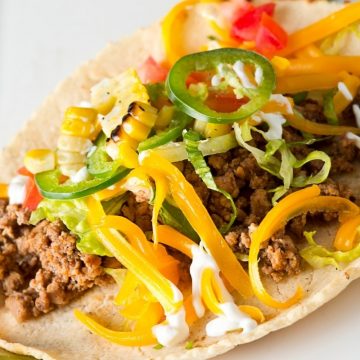 These authentic Mexican Tacos are bursting with delicious flavors and textures. They feature perfectly seasoned ground beef, crispy taco shells, soft flour tortillas, and the best toppings!