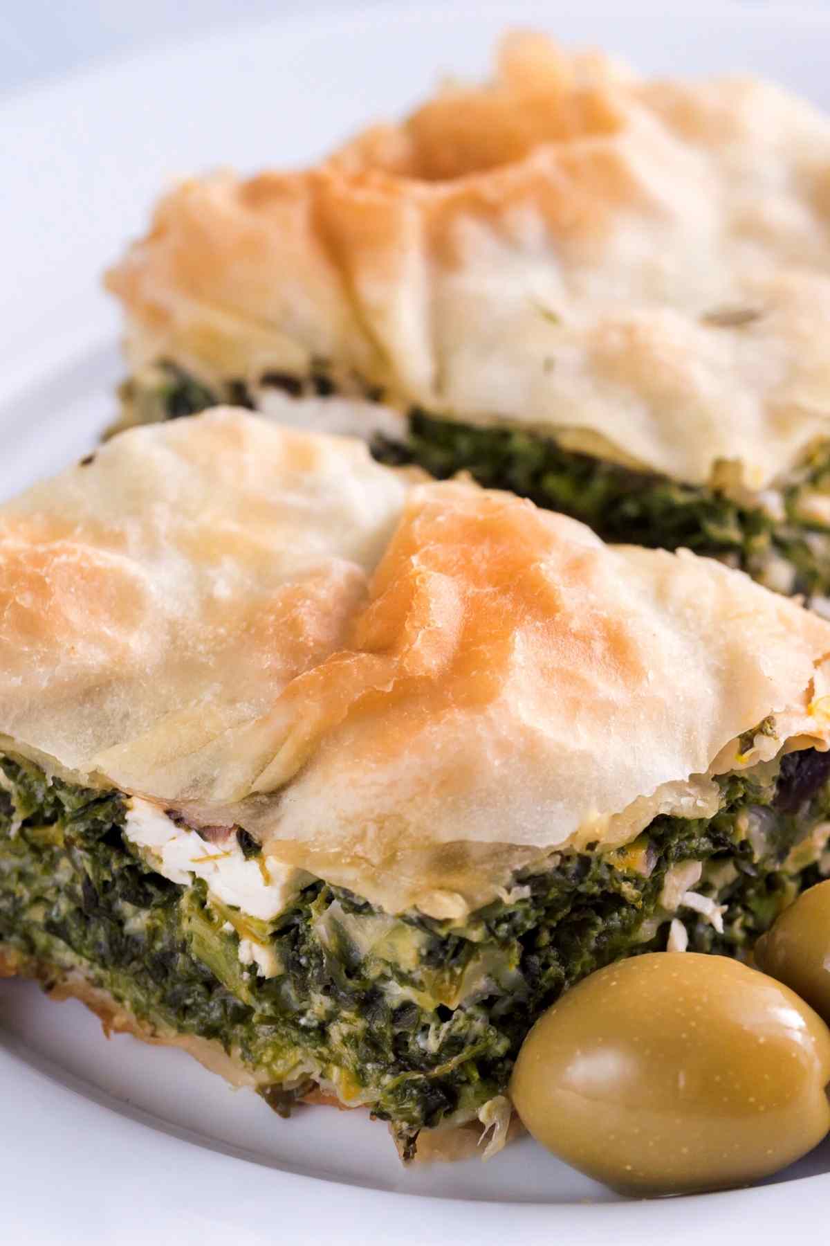 Spinach pie is a Greek delicacy also known as “Spanakopita.” If you haven’t tried this delectable treat yet, now is the time! Made with layer upon layer of crunchy phyllo dough, filled with spinach and feta cheese, and baked to golden perfection, spinach pie is a comforting, filling, and scrumptious food.