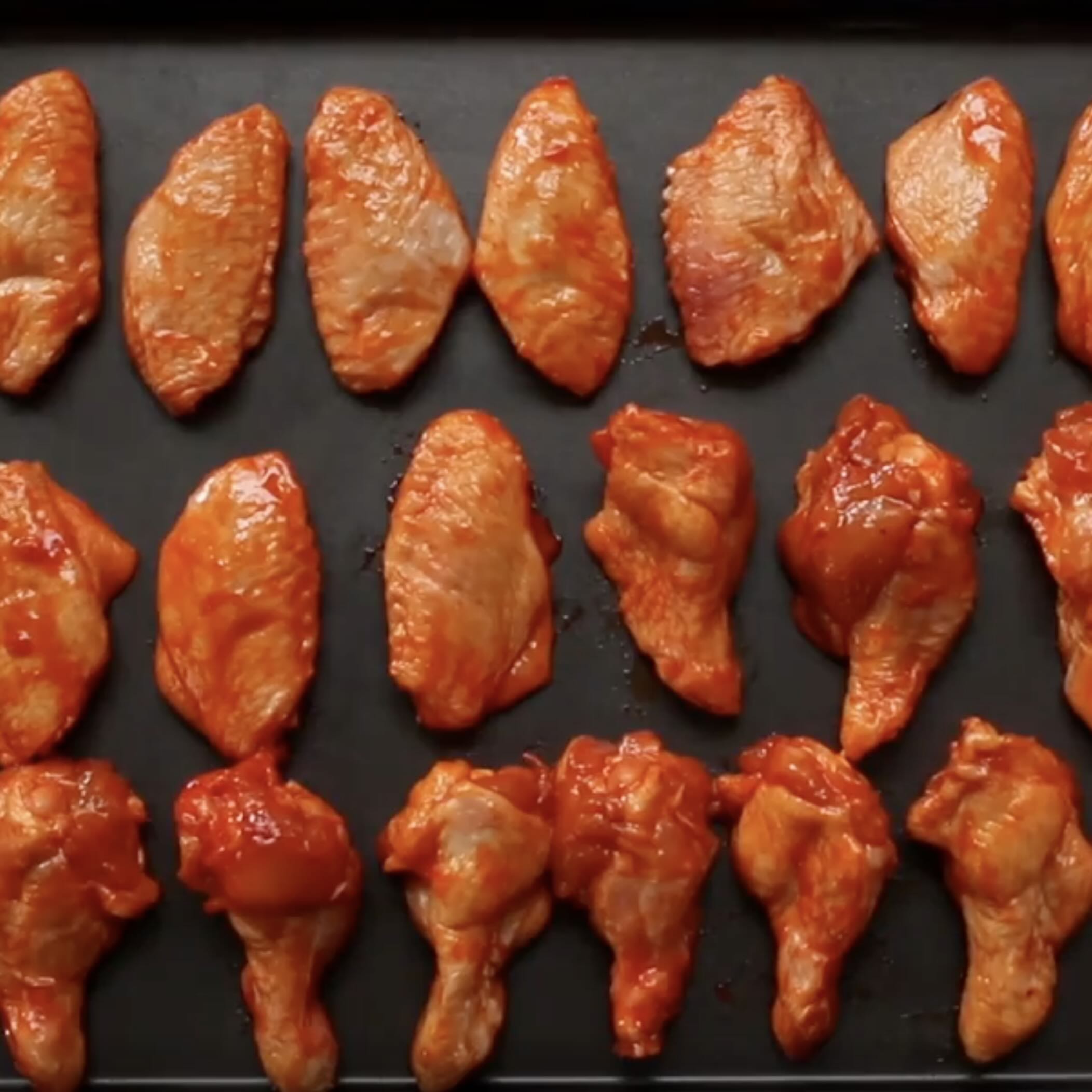 Seasoned chicken wings arranged on a baking sheet, ready to be baked