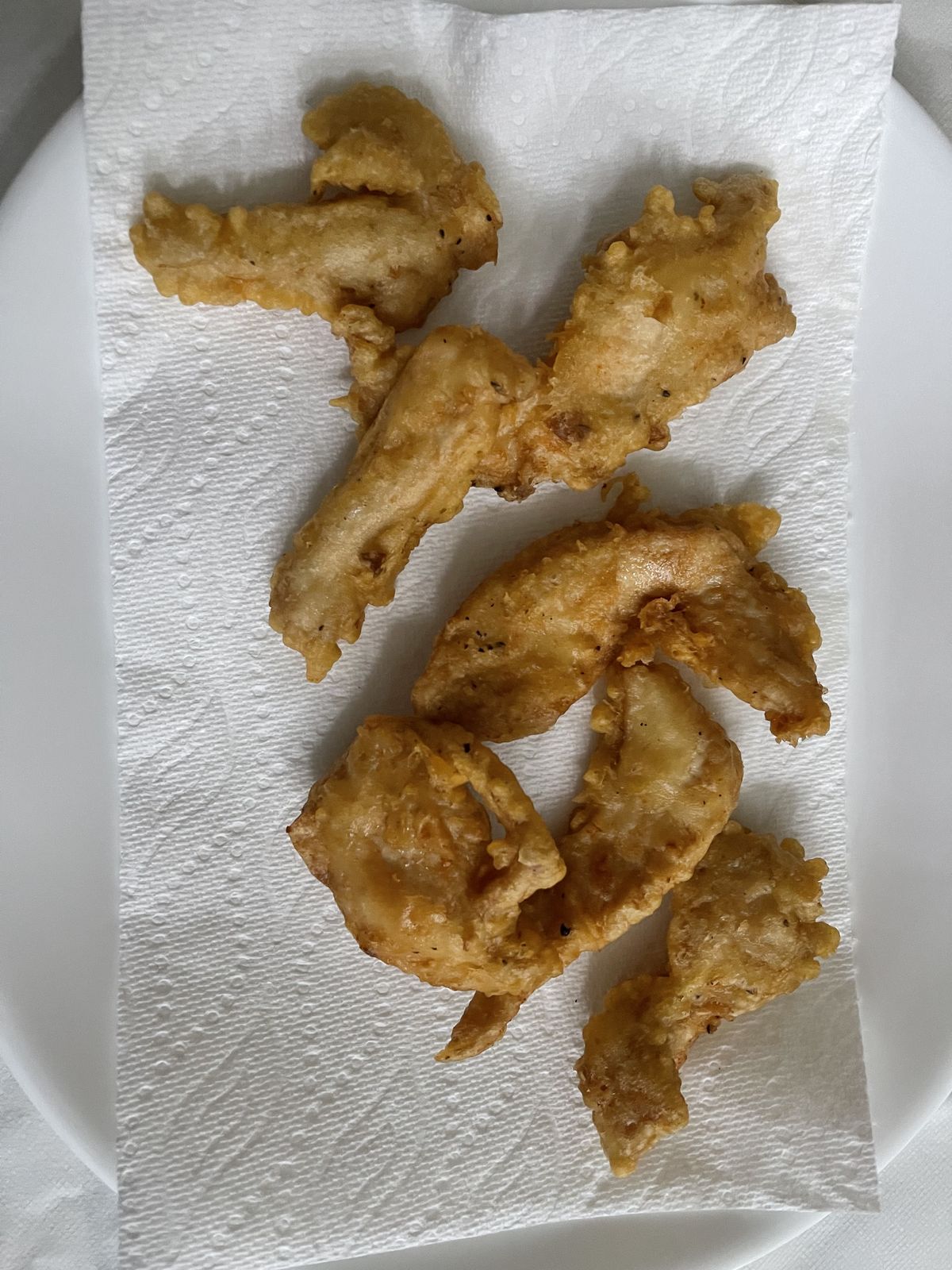 Fried chicken pieces draining on paper towels