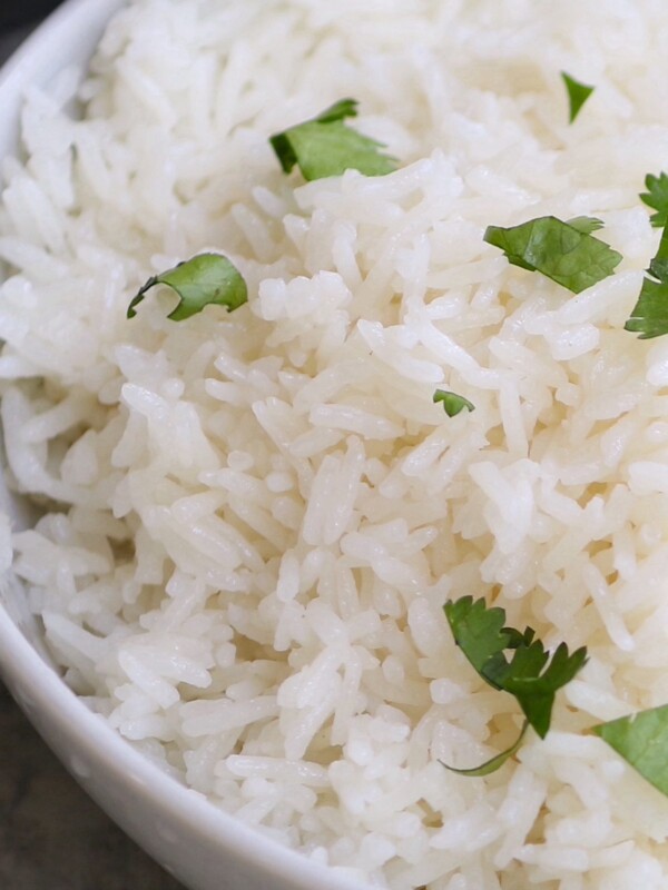 The easiest and foolproof way to make restaurant-quality Coconut Rice is to cook it in a rice cooker. It comes out perfectly FLUFFY with tropical flavors of coconut ever time! It takes less than 2 minutes to put everything into the rice cooker. Jasmine rice and coconut milk cook together in the rice cooker for a super delicious side dish!
