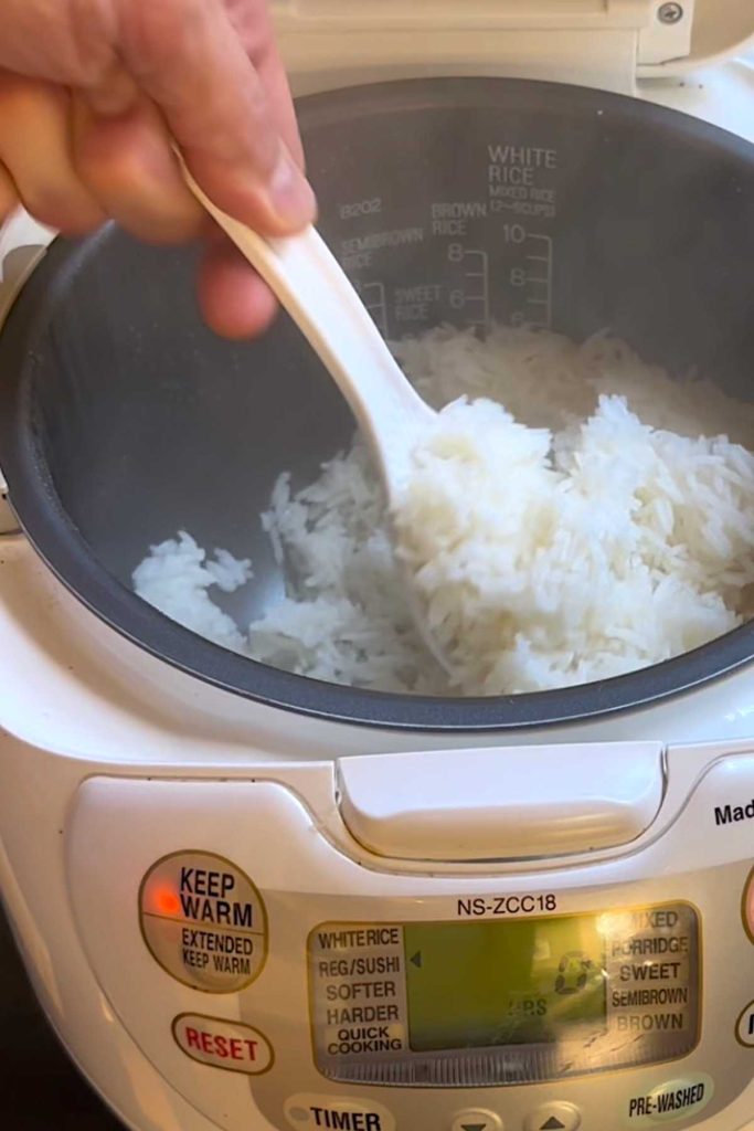 Fluff the rice with a rice cooker paddle