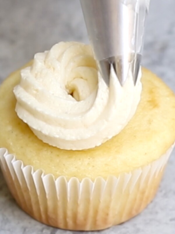 Close-up showing piping the frosting onto a cupcake