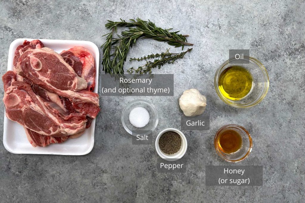Lamb Shoulder Chops Ingredients on the counter: rosemary, garlic, oil, honey, salt, and pepper