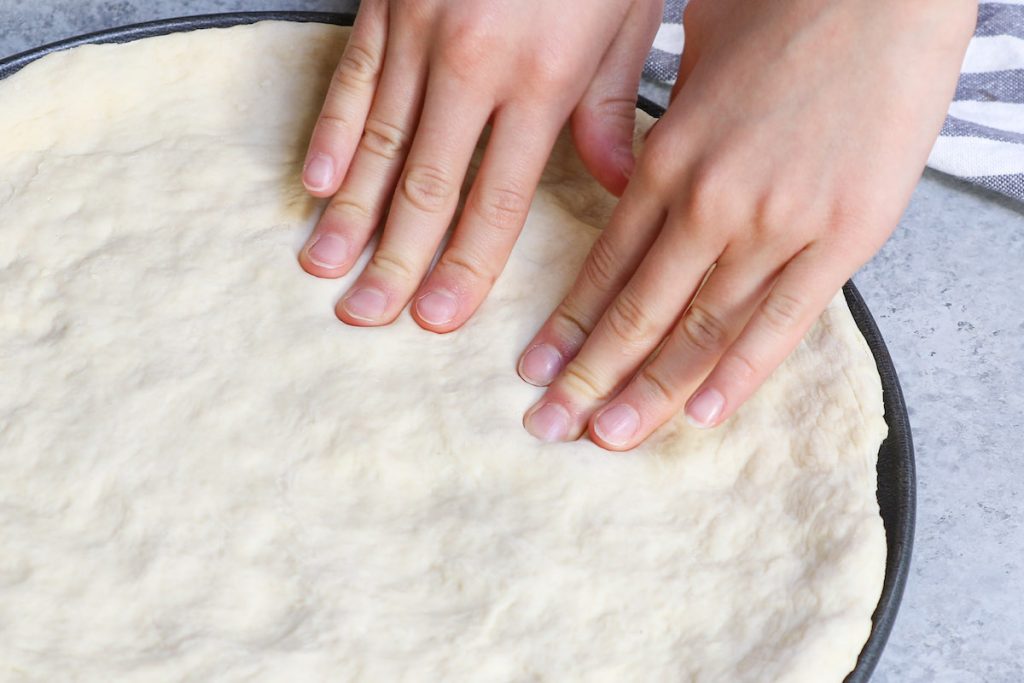 Rolling out the dough by pressing