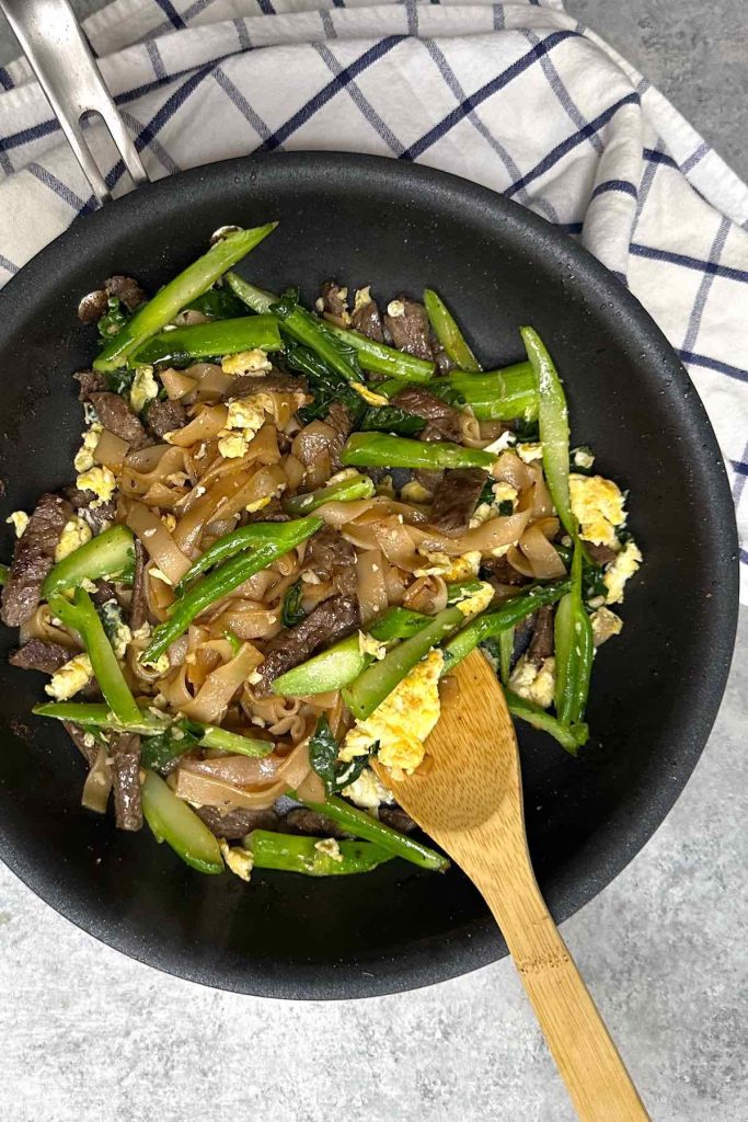 This homemade Pad See Ew recipe is loaded with tender wide rice noodles, Chinese broccoli, protein of your choice (beef, chicken, shrimp, or tofu), scrambled eggs, and coated with a savory and sweet sauce. Ready in less than 30 minutes!