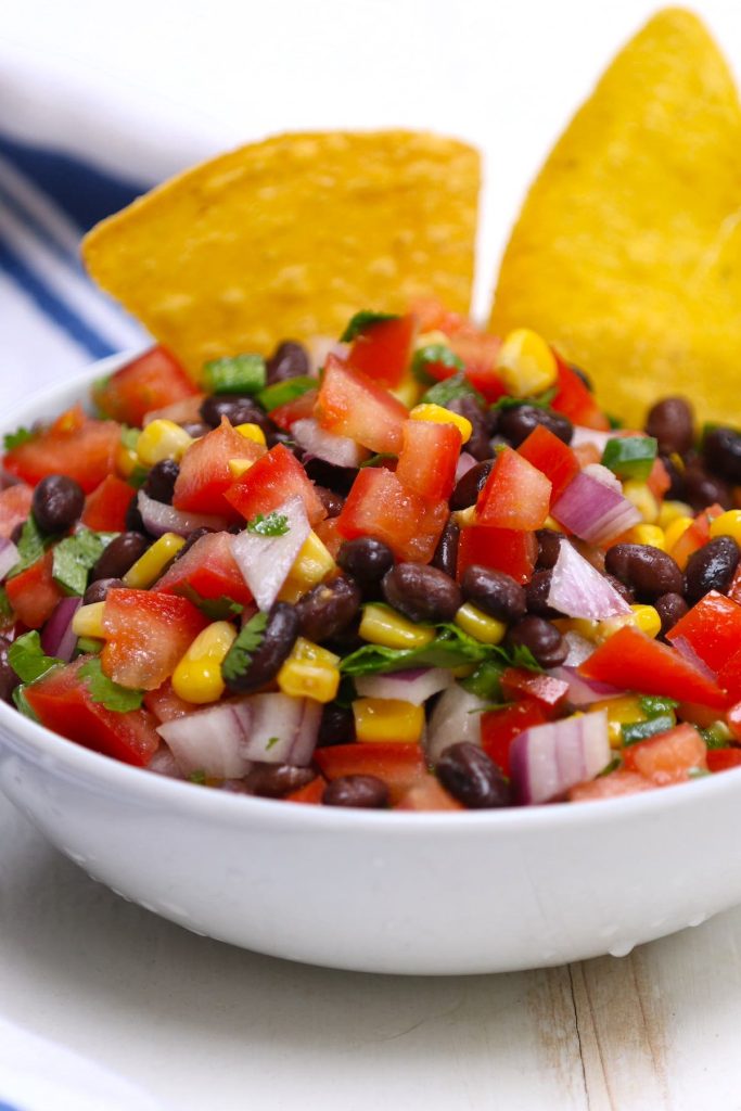 Up your game with this super easy, fresh, and flavorful black bean and corn salsa recipe. Serve it as a dip with tortilla chips, or top it onto tacos, nachos, burritos, and more.
