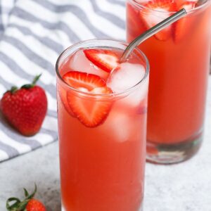 Copycat recipes &ndash; homemade strawberry acai refresher with sliced strawberries and ice in tall glasses with metal straws