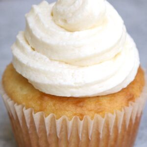 Dessert recipes &ndash; vanilla cupcake topped with a swirl of creamy buttercream frosting in a paper liner
