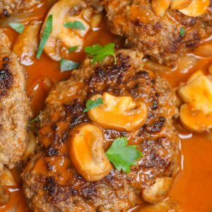 Dinner recipes &ndash; Salisbury steak patties with mushroom gravy and fresh parsley in a skillet