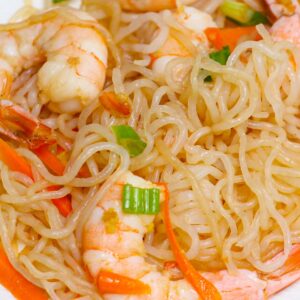Low carb recipes &ndash; shirataki miracle noodles stir-fried with shrimp, carrots, and green onions on a white plate