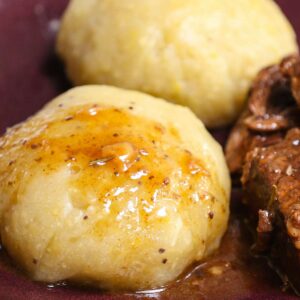 Side dish recipes &ndash; two rounds of African fufu with stew sauce on a dark purple plate