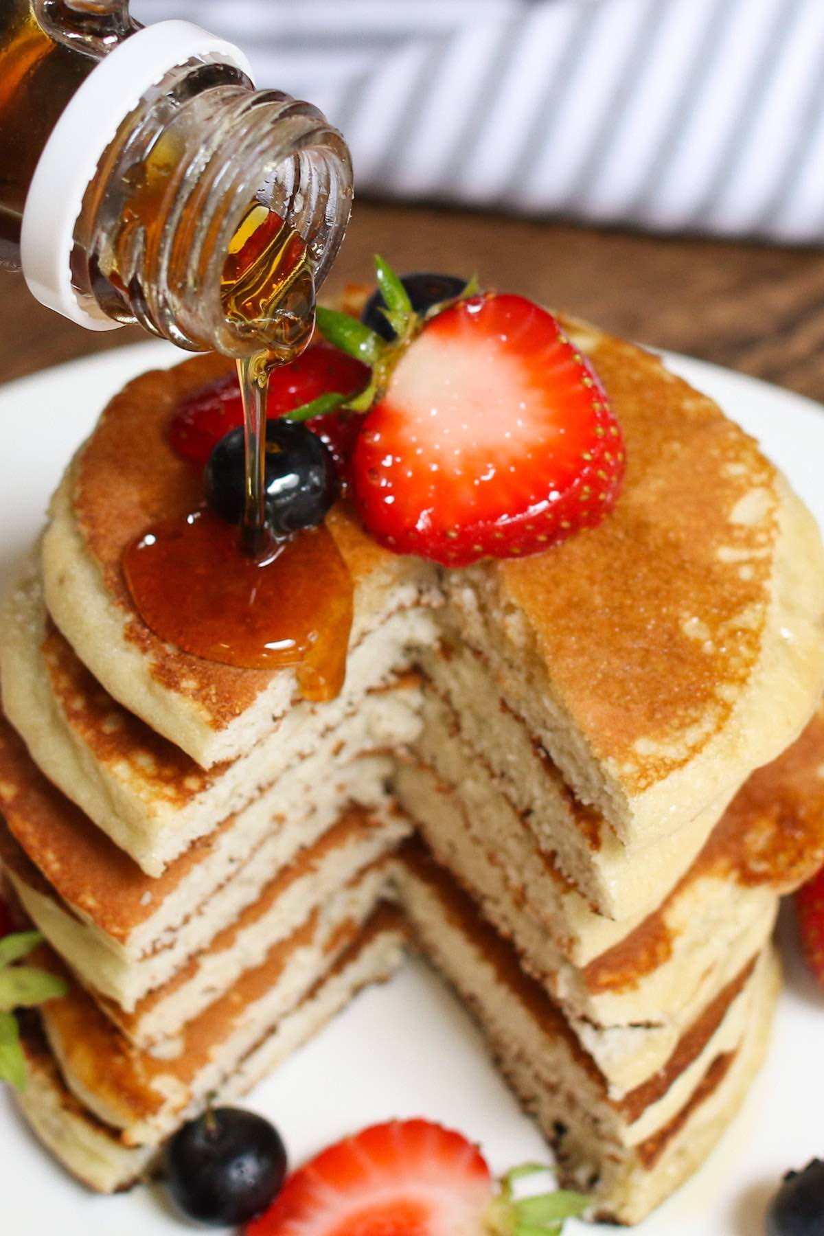pouring maple syrup onto the pancakes
