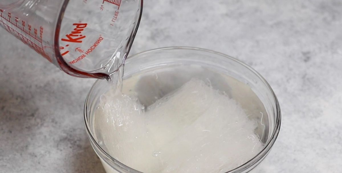 dried bean thread noodles soaking in warm water in a bowl